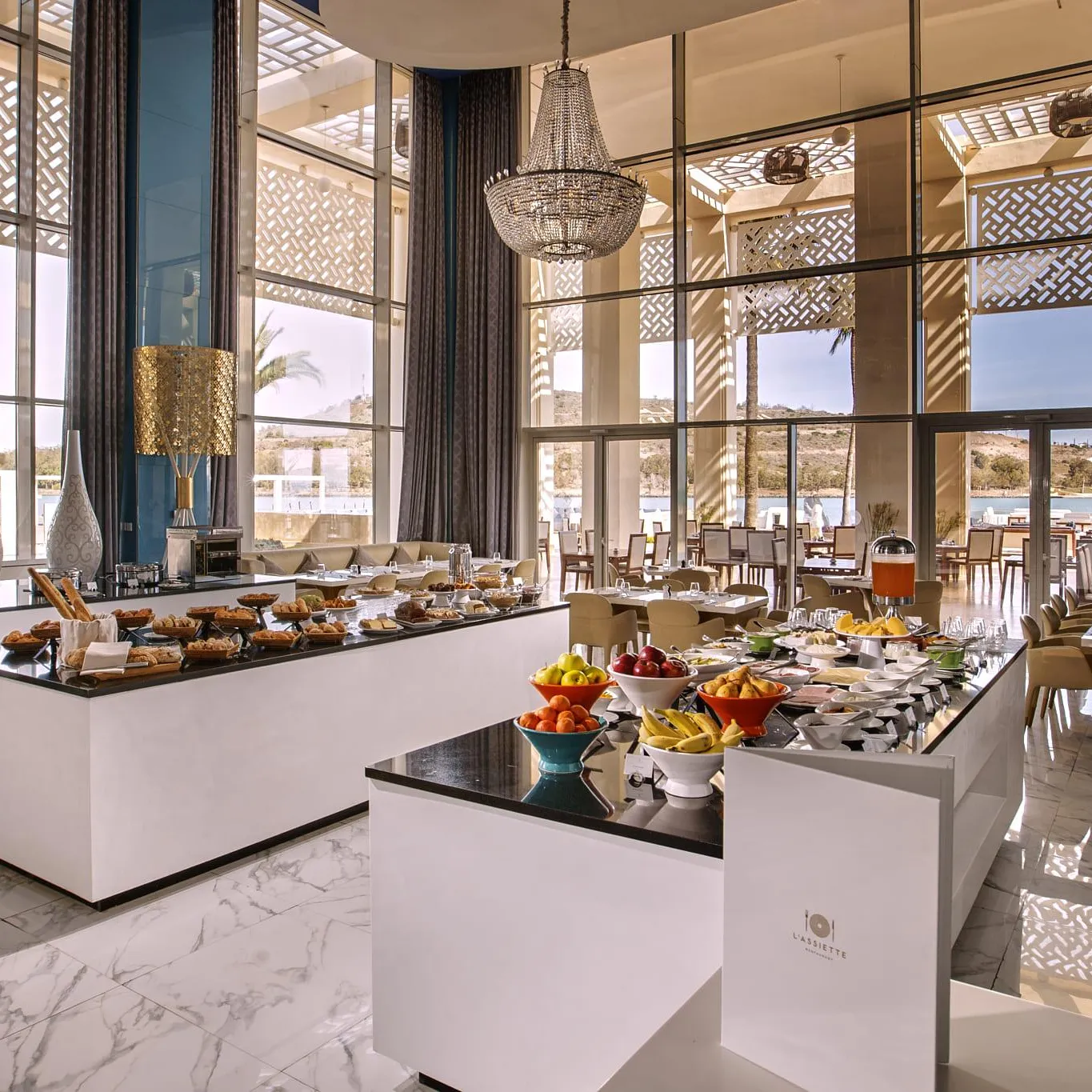 Restaurant élégant avec buffet de petit-déjeuner, grandes fenêtres et vue sur la mer